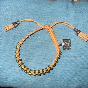 This is a peach colored bracelet with gold accents.